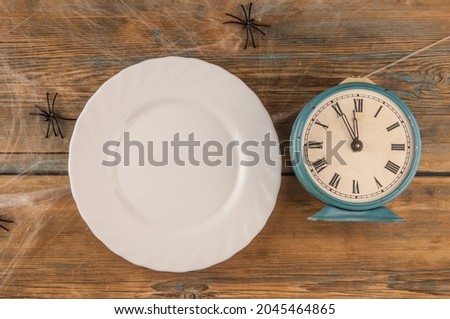 Halloween table blank dish with spider web on wood background. Flat lay, top view trendy holiday concept.