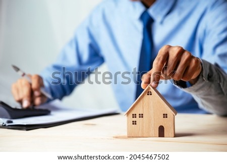 House model with real estate agent and customer discussing for contract to buy house, insurance or loan real estate,real estate concept.