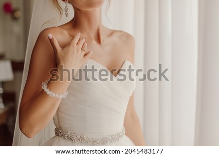 Exciting moment of waiting for groom, wedding day, unrecognizable bride looking out window. Concept of bride's gathering for celebration. High quality photo Royalty-Free Stock Photo #2045483177