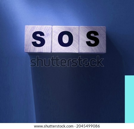 SOS symbol on wooden cubes. Save Our Souls call for help concept.