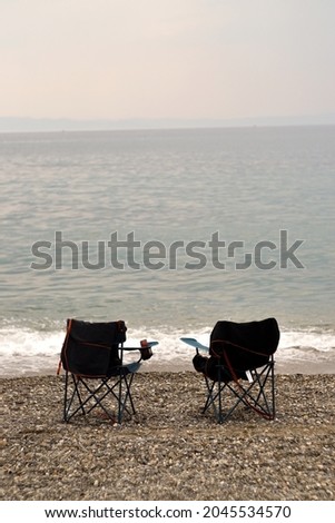 Collapsible beach chairs on pebble stone beach
