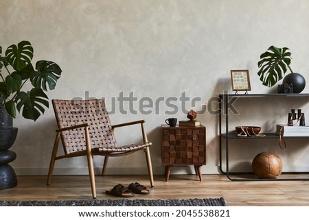 Creative interior composition of elegant masculine living room with copy space, brown armchair, designed commode, industrial shelf and personal accessories. Template.  