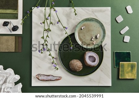 Stylish flat lay composition of creative architect moodboard design with samples of building, textile and natural materials and personal accessories. Top view, green background, template.