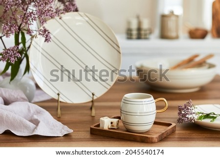 Elegant composition of classy dining room interior design with rustic table, beautiful porcelain, flowers and kitchen accessories. Beauty in the details. Template. Royalty-Free Stock Photo #2045540174