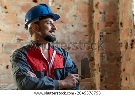 Bricklayer poses smiling while renovating a bathroom Royalty-Free Stock Photo #2045576753