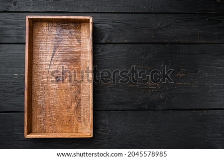 Empty dark wooden box set with copy space for text or food, top view flat lay, on black wooden table background