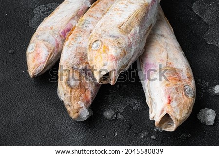 Frozen Goatfish raw fish set, on black dark stone table background
