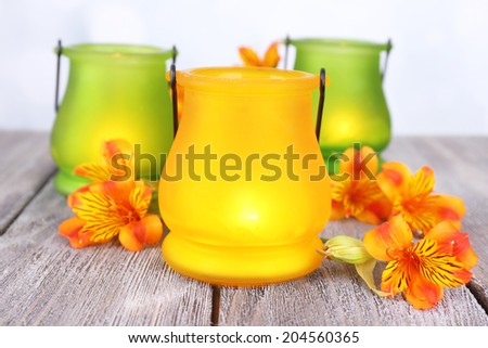Bright icon-lamps with flowers on table on bright background