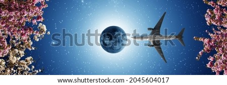 Passenger plane flying in the panoramic blue night sky. full moon and stars. pink and white spring flowers. bottom-up view. visual for stretch ceiling decoration
