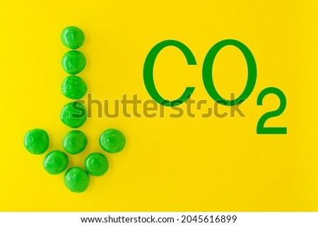 Reduce carbon dioxide emissions and limit global warming and climate change concept. CO2 sign and green arrow pointing down