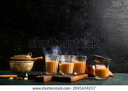 Indian masala chai tea. Spiced tea with milk and spices on dark background.  cafe, retro, bar, ethnic, desi, restaurant, hotel concepts. Royalty-Free Stock Photo #2045634257