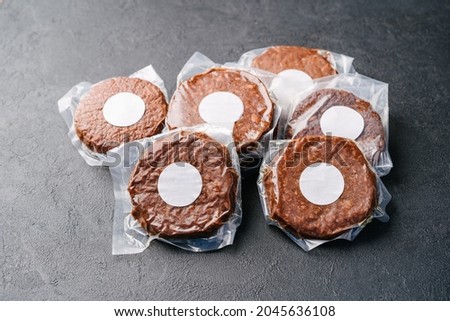 Raw vegan meatless cutlets in vacuum film, hamburger on a dark background. Mockup sticker Royalty-Free Stock Photo #2045636108