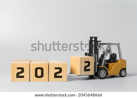 2022 new year background concept. happy new year industrial concept, forklift carrying box to complete 2022 text.