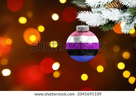Colorful blurred background and applied the flag of genderfluid on the New Year's toy. New Year 2022 Celebration