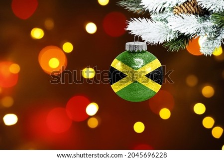 Colorful blurred background and applied the flag of Jamaica on the New Year's toy. New Year 2022 Celebration