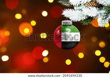 Colorful blurred background and applied the flag of United Arab Emirates on the New Year's toy. New Year 2022 Celebration