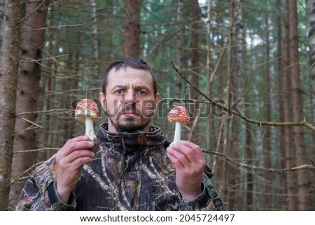 A man holds hallucinogenic amanita mushrooms in his hands.