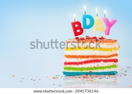 Birthday cake with happy birthday candles on blue background with copy space for your greetings