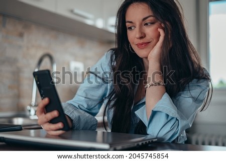 Young attractive businesswoman taking selfie with her smartphone while in her home office