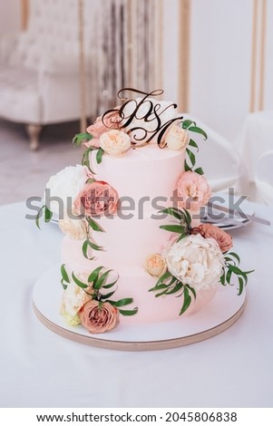 Wedding cake decorated with natural flowers and cream. 