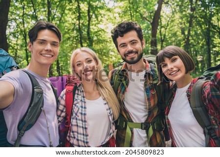 Self-portrait of attractive four cheerful people hikers exploring country world on fresh air vacation outdoors
