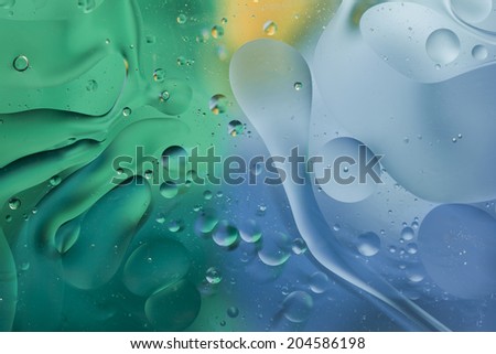 Abstract pattern of colored oil bubbles on water 