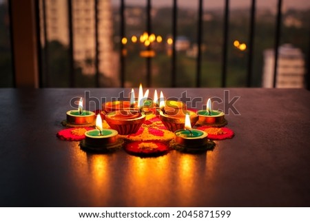 Diwali celebration Indian festival of lights Diya oil lamp and colors Rangoli decoration bright colorful flowers flowerbed copy space greetings Deepavali Hindu festival North India, Mumbai Delhi India Royalty-Free Stock Photo #2045871599