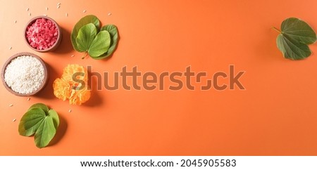 Happy Dussehra. Yellow flowers, green leaf and rice on orange background. Dussehra Indian Festival concept. Royalty-Free Stock Photo #2045905583