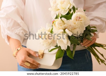 Fashionable woman holding bouquet of peony flowers, closeup