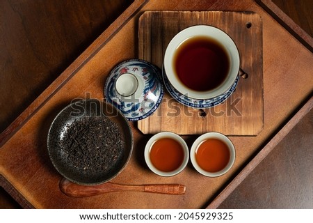chinese traditional porcelain tea cup and tea leaf on wooden ancient board