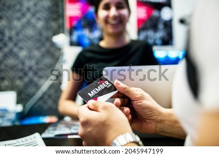 Woman holding a fitness membership card Royalty-Free Stock Photo #2045947199