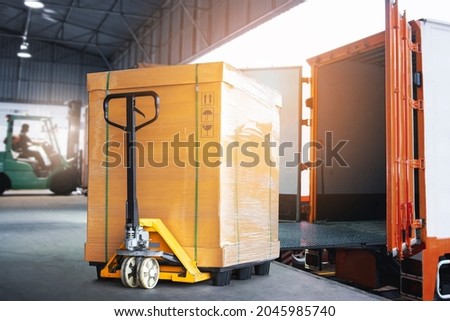 Cargo Box with Hand Pallet Truck  is Loading into a Container. Shipment Supply Chain Delivery. Warehouse Logistics. Cargo Freight Truck Transportation.	 Royalty-Free Stock Photo #2045985740