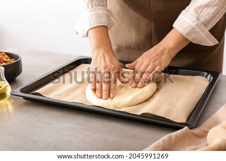 Woman preparing Turkish Pizza at table, closeup