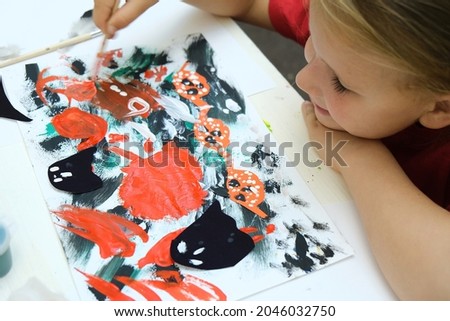 Child making abstract card for the  halloween. Funny crafts from paper. Halloween decor. The concept for Halloween. DIY. Children's art project