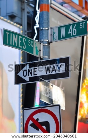 Signpost at Times Squre and 46th Street downtown Manhattan New York City. One Way and Road signs with blurred broadway background.