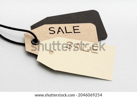 Group of cardboard price tags with die cut SALE text isolated on gray background