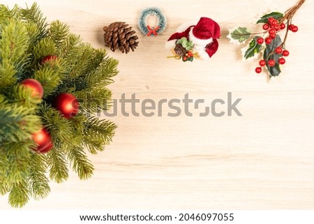 Christmas tree, pine cone, wreath, Santa figurine and mistletoe  ornaments on wooden background
