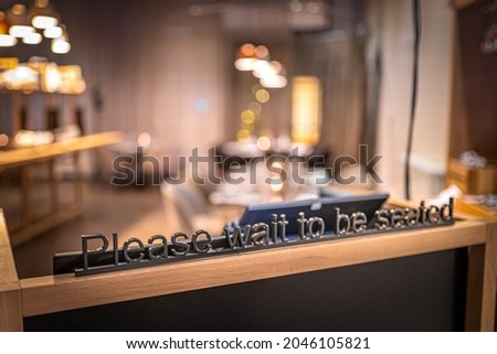Image of Wait to be seated metal sign in the restaurant