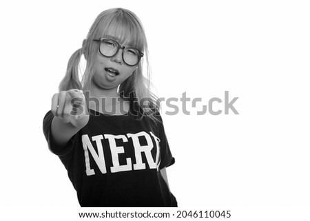 Studio shot of young Asian woman as nerd with eyeglasses isolated against white background in black and white