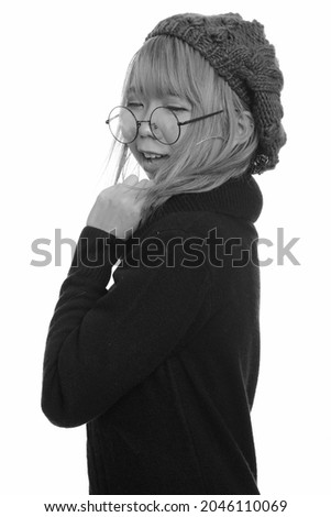 Studio shot of young Asian woman wearing turtleneck sweater isolated against white background in black and white