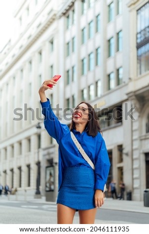 Happy businesswoman taking a selfie on the street