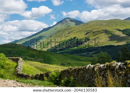 Along the West highland Way in Scotland. An old stone wall runs along the hiking path in the Glen Falloch valley Royalty-Free Stock Photo #2046130583