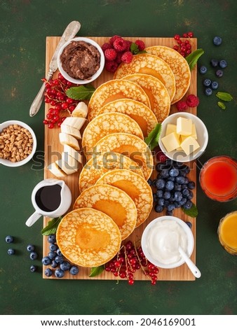 american pancake board with berries maple syrup butter