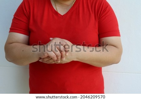 Woman holding her wrist and fingers feeling pain, suffering and numbness. Concept of Guillain barre syndrome and hand numbness after coronavirus vaccination.