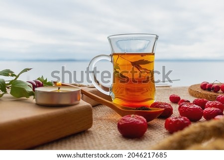 Black tea and rose hips on the background of a cloudy sky