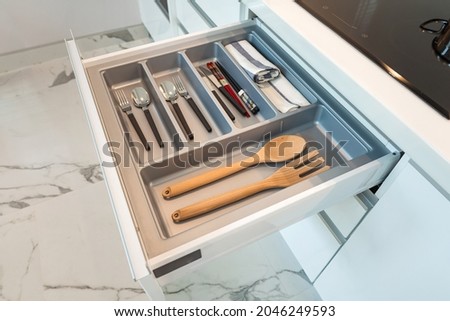Modern kitchen, Open drawers, Set of cutlery trays in kitchen drawer. Plastic equipment for drawer inserts.    Royalty-Free Stock Photo #2046249593