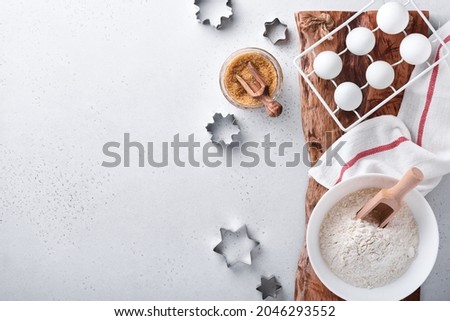Ingredients for cooking homemade baking. Baking background with flour, eggs, kitchen tools, utensils and cookie molds on white marble table. Top view. Flat lay style. Mock up.