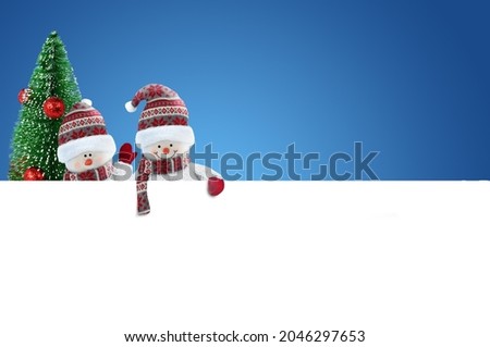 Two Cute Snowmen with blank banner on blue background