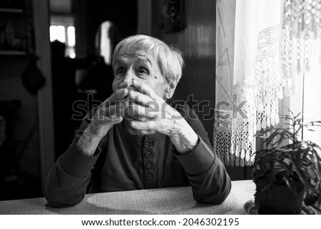 An old woman during a lively conversation. Black and white photo.