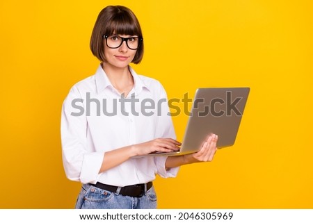 Photo of charming programmer lady hold netbook wear eyewear white shirt isolated yellow color background